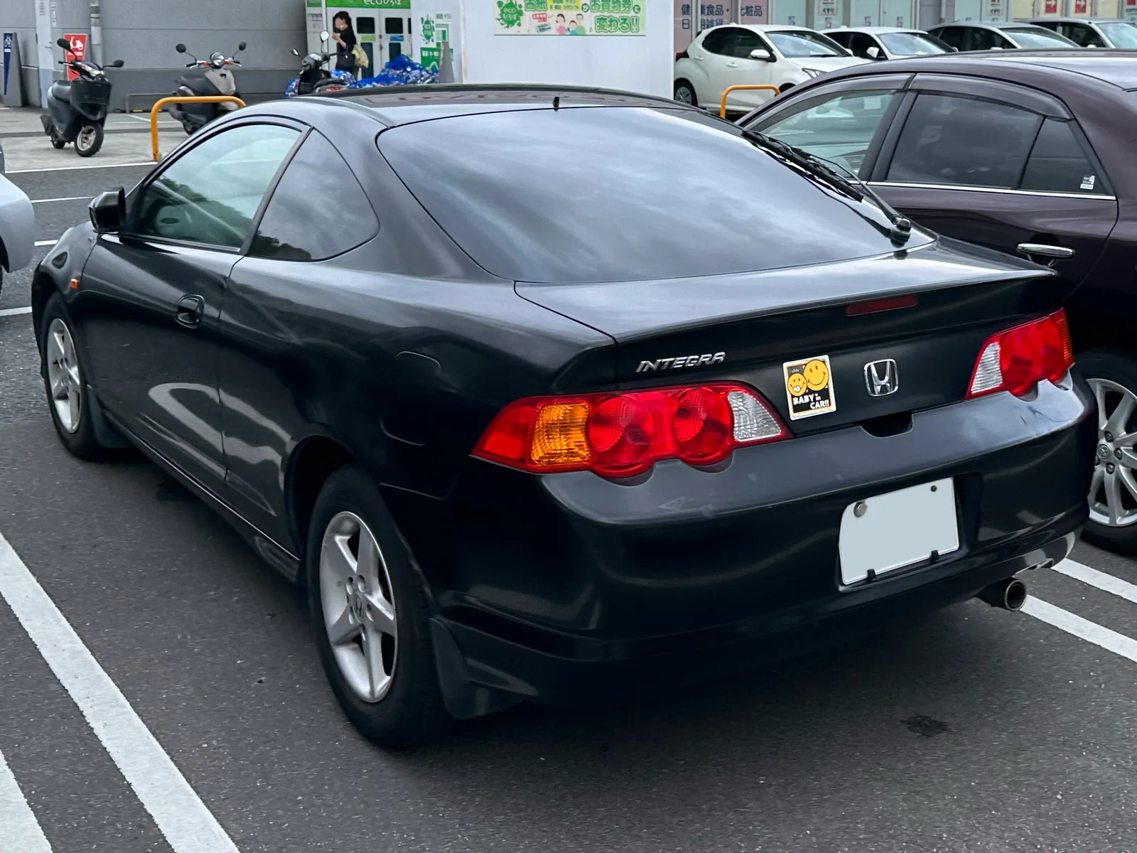 Honda Integra DC5 สีดำ มุมท้ายสามส่วน จอดในลานจอดรถญี่ปุ่น เห็นโลโก้ Integra
