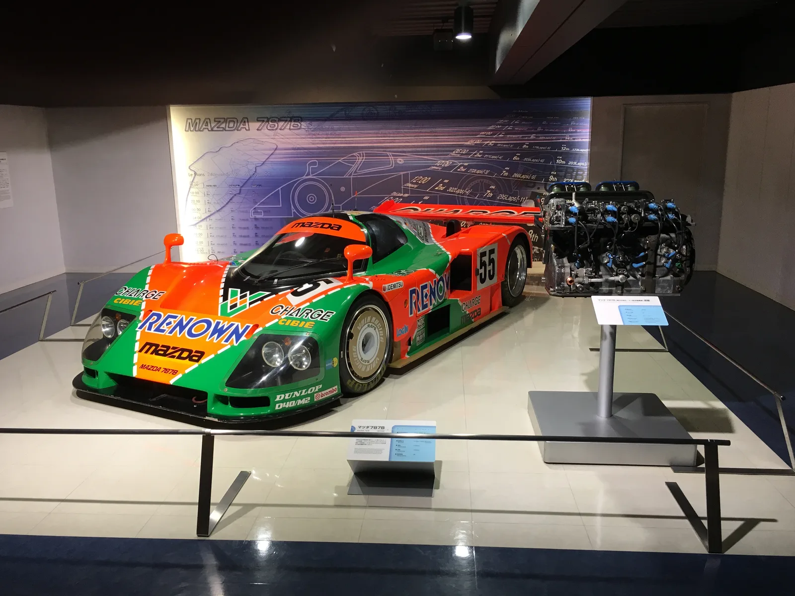 787B จอดคู่เครื่องยนต์โรตารี R26B ในพิพิธภัณฑ์มาสด้า หลังเป็นภาพพิมพ์เขียวตัวรถ