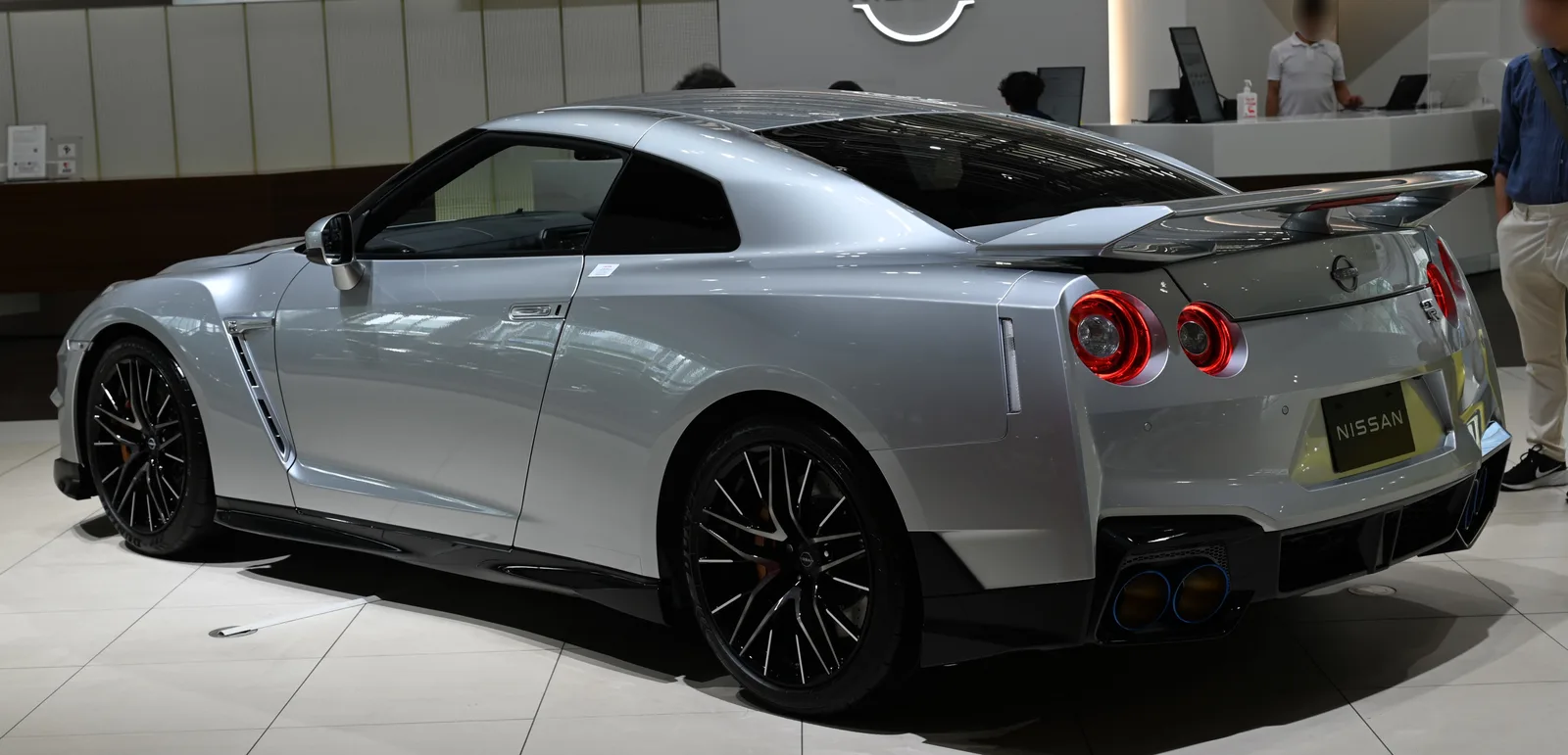 GT-R R35 สีเงิน มุมท้ายเฉียง จัดแสดงในโชว์รูม เห็นไฟท้ายวงกลมชัดเจน