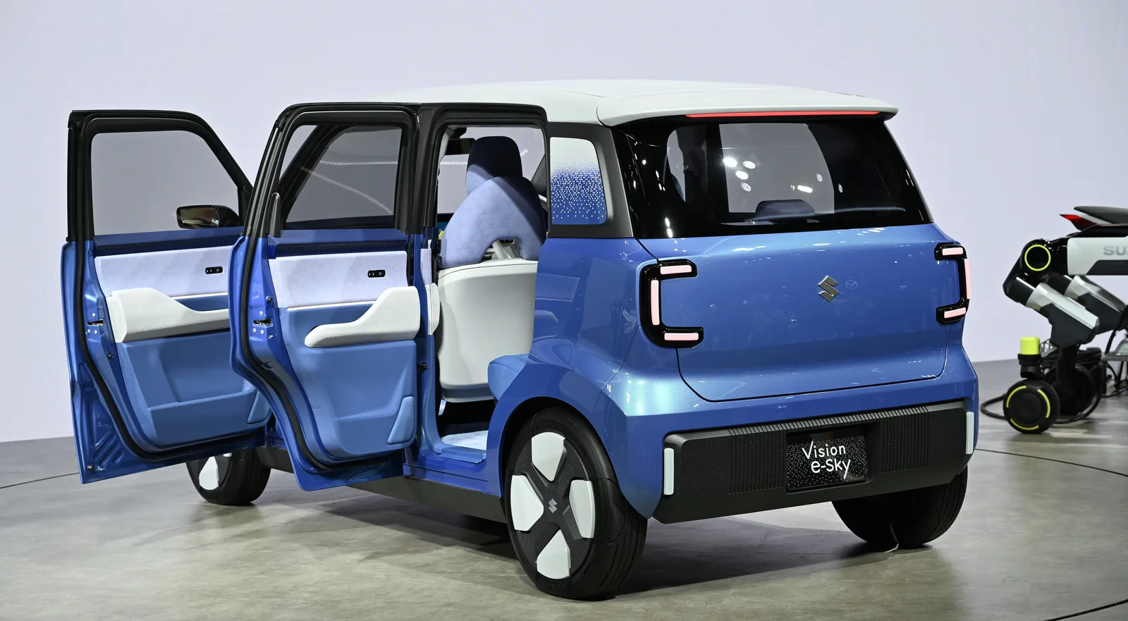 มุมท้ายสามส่วน ประตูเปิดโชว์เบาะในห้องโดยสาร เห็นป้าย Vision e-Sky ท้ายรถชัดเจน