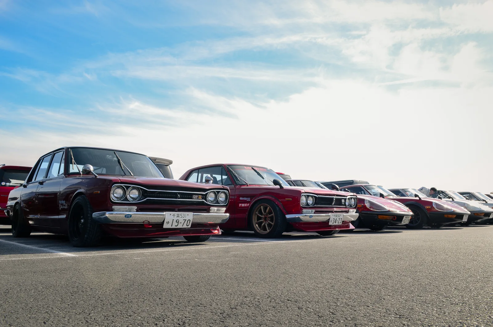ขบวน Skyline GT-R รุ่นคลาสสิกสีแดงเลือดหมู จอดเรียงแถวในลานจอด บรรยากาศงาน Nismo Festival
