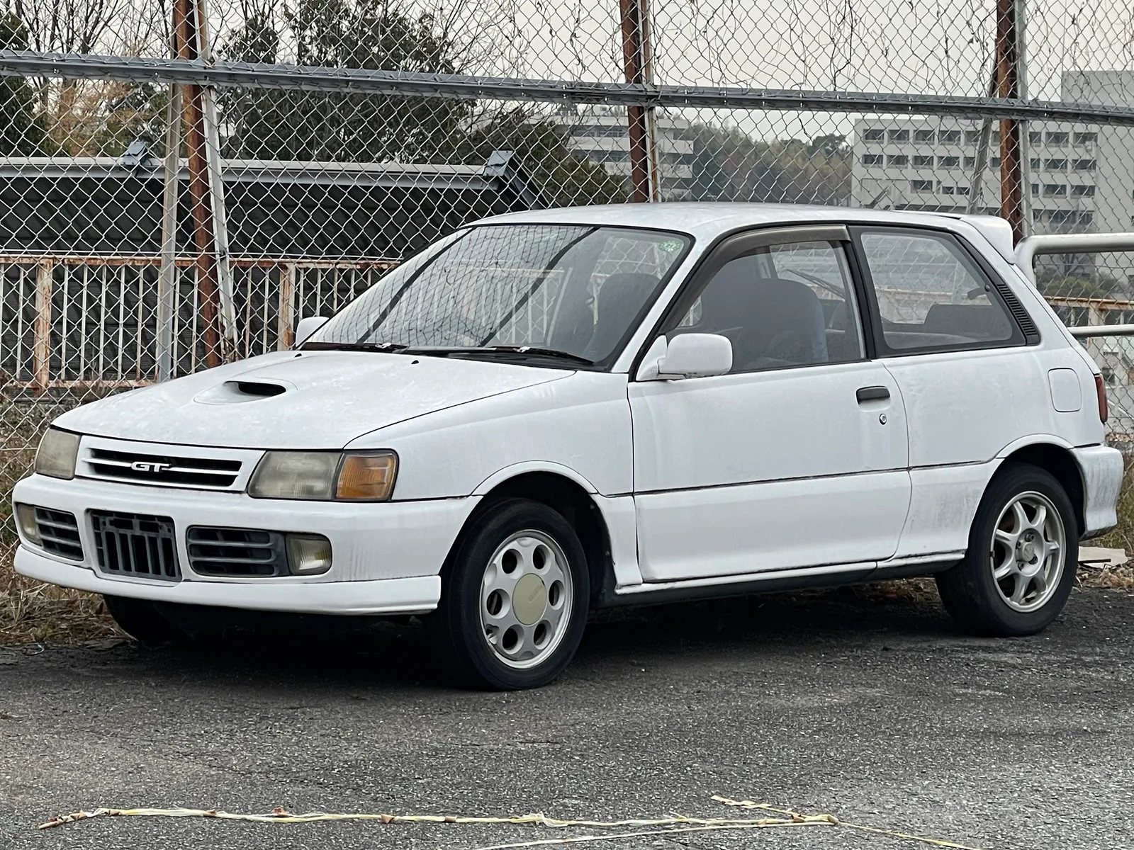 Toyota Starlet GT EP82 สีขาว มุมหน้าสามส่วนสี่ ถ่ายในญี่ปุ่น เห็นสกู๊ปฝากระโปรงชัด