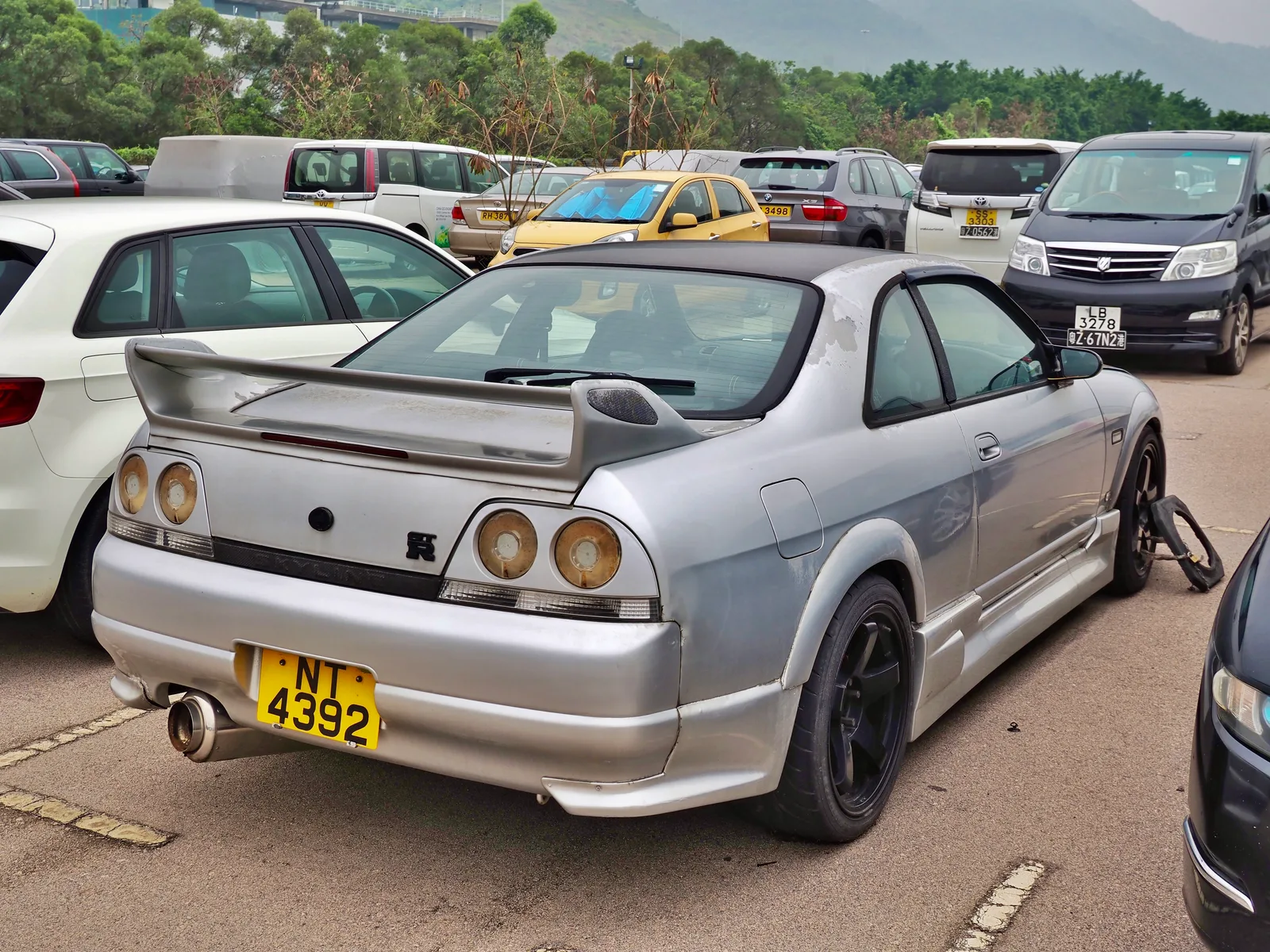Nissan Skyline GT-R R33 สีเงิน มุมท้ายสามส่วน โชว์สปอยเลอร์ใหญ่และไฟท้ายวงกลม