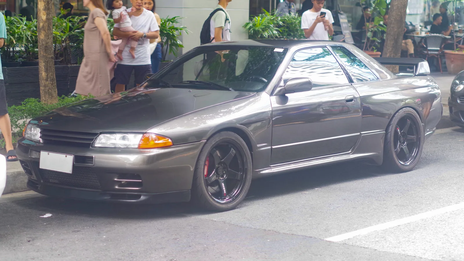 GT-R R32 สีเทา ล้อสไตล์ TE37 จอดริมถนนในเมือง มุมหน้าสามส่วน สายบุกเบิกรุ่นแรก