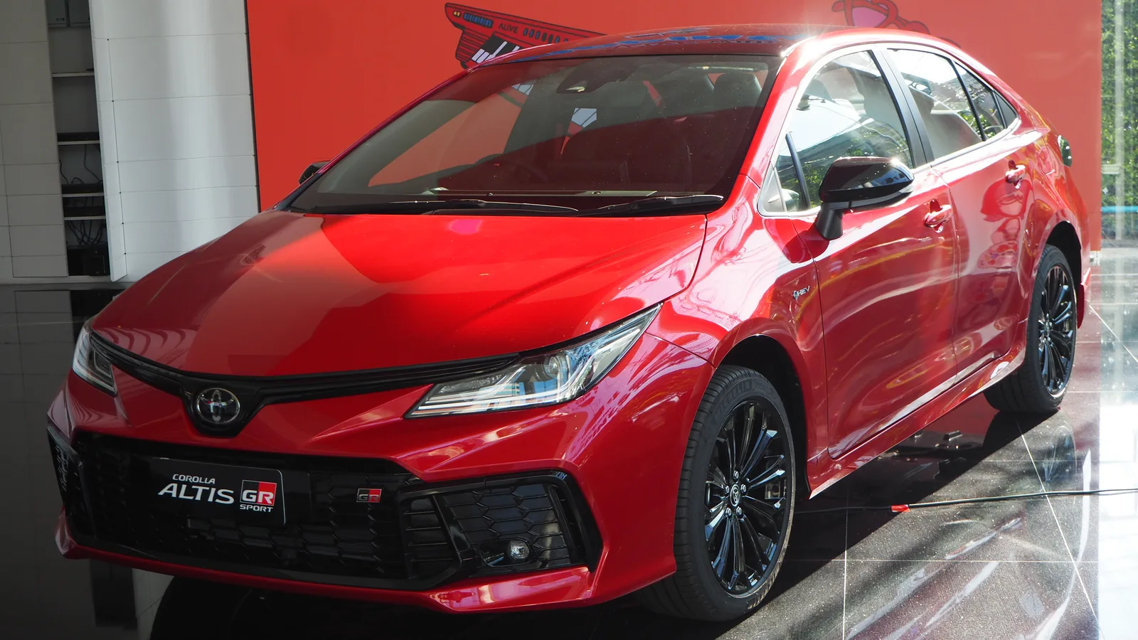 Toyota Corolla Altis GR Sport สีแดง มุมหน้าสามส่วน จอดในโชว์รูมพื้นหลังสะอาด