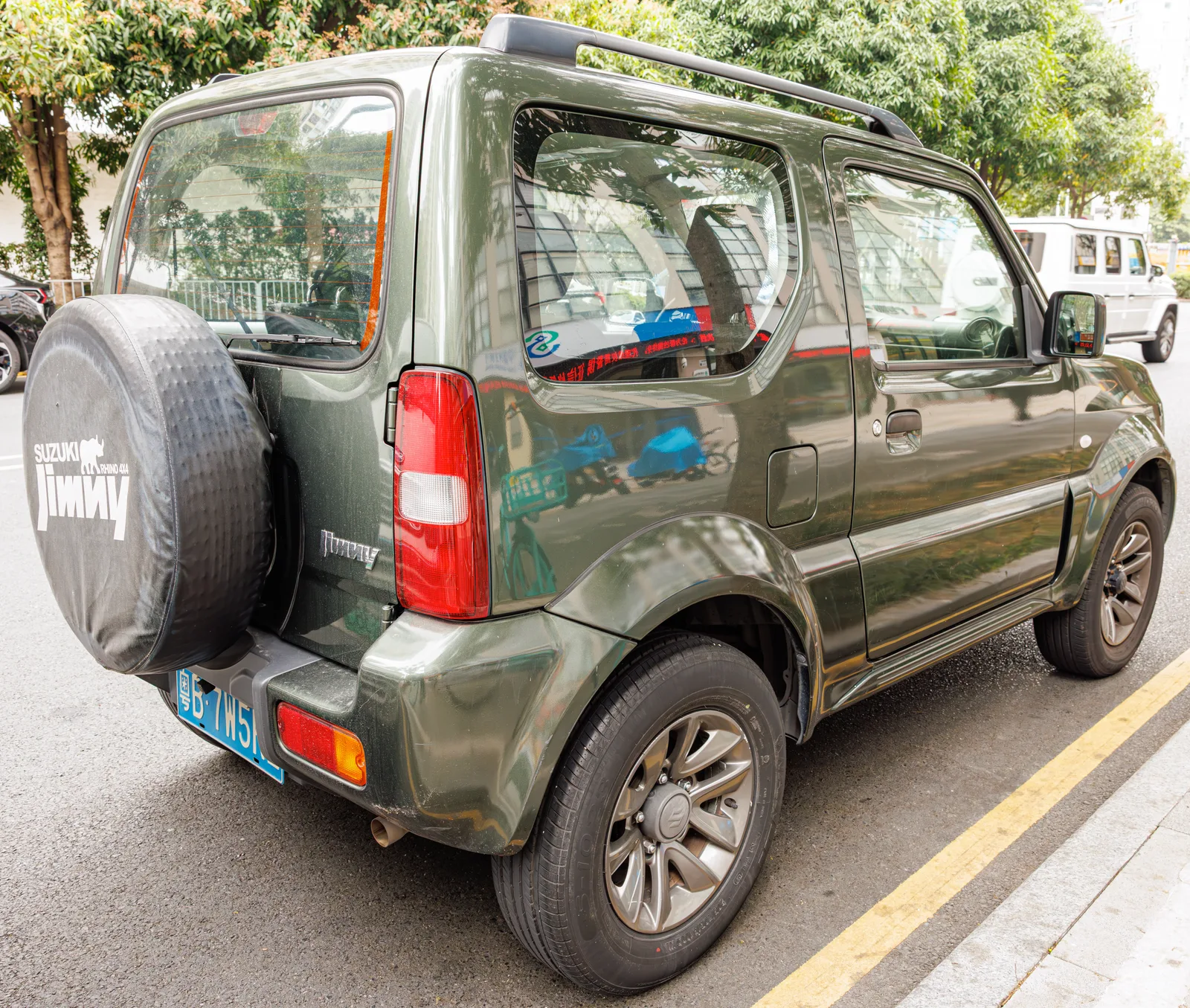 Jimny เขียวเข้ม มุมท้าย 3/4 เห็นยางอะไหล่หลังพร้อมปลอกคลุม