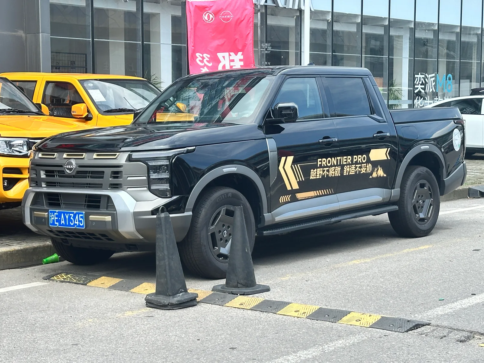 Nissan Frontier Pro สีดำ มุมหน้าสามส่วน ติดลายสติกเกอร์ จอดหน้าโชว์รูมในจีน