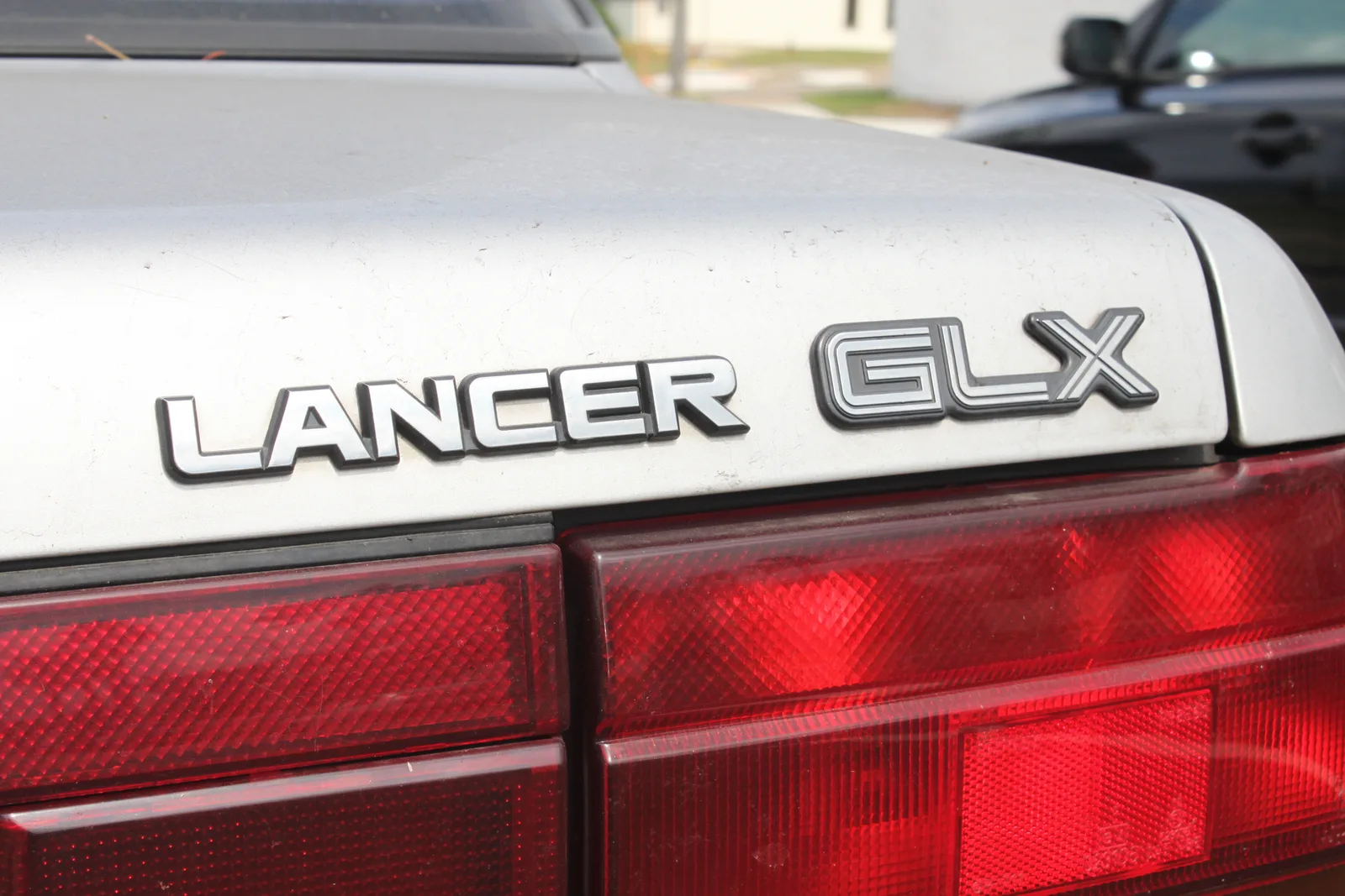ดีเทลป้าย Lancer GLX บนฝากระโปรงท้าย พร้อมไฟท้ายลายเพชรแบบฉบับยุค 90