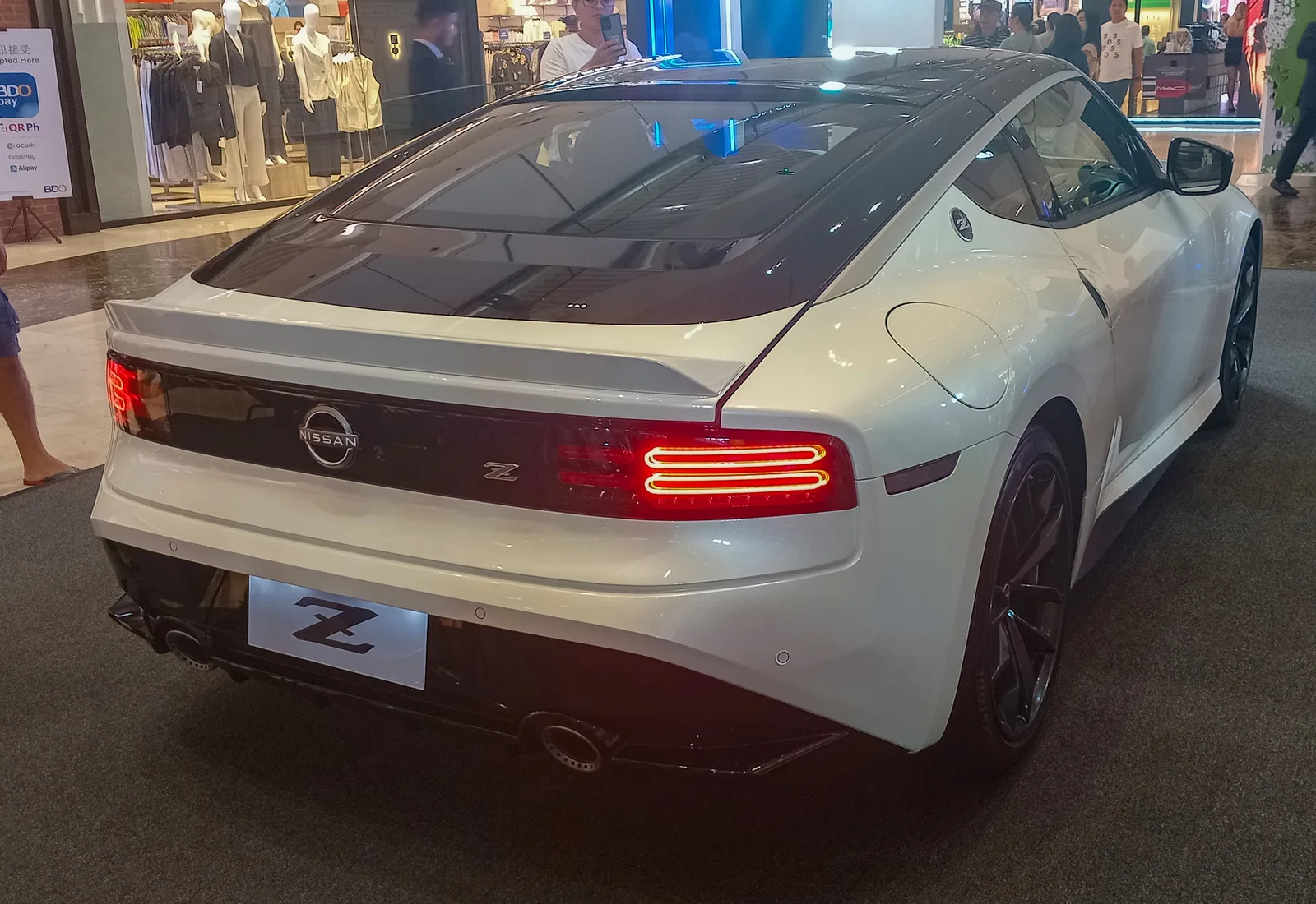Nissan Z (RZ34) สีขาวหลังคาดำ มุมท้ายสามส่วน เห็นสปอยเลอร์และไฟท้าย