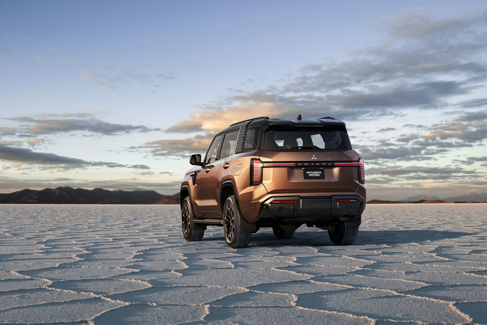 Pajero ใหม่ มองท้ายสามส่วน ไฟท้ายแนวนอนยาวเต็มบาน จอดบนทะเลเกลือยามเย็น