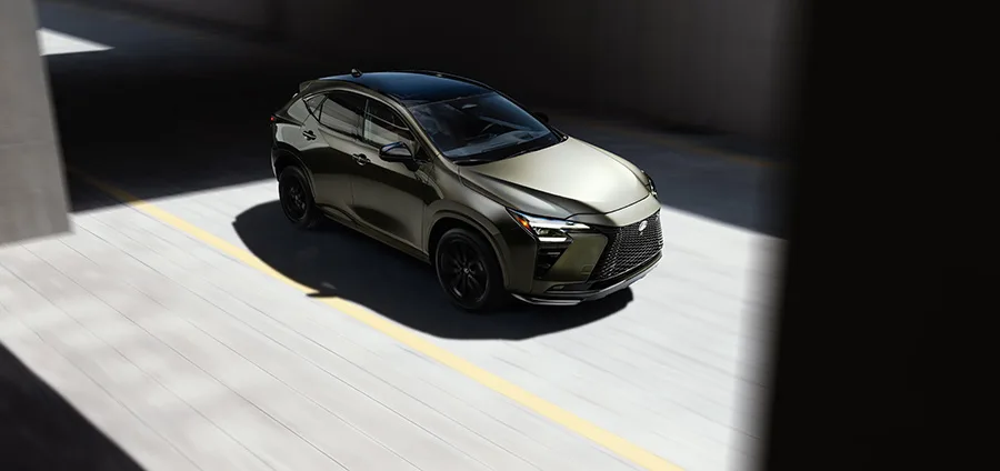 Lexus NX รุ่นใหม่ มุมสูงด้านหน้า สีเขียวมะกอก ล้อดำ บนลานแสงเงา