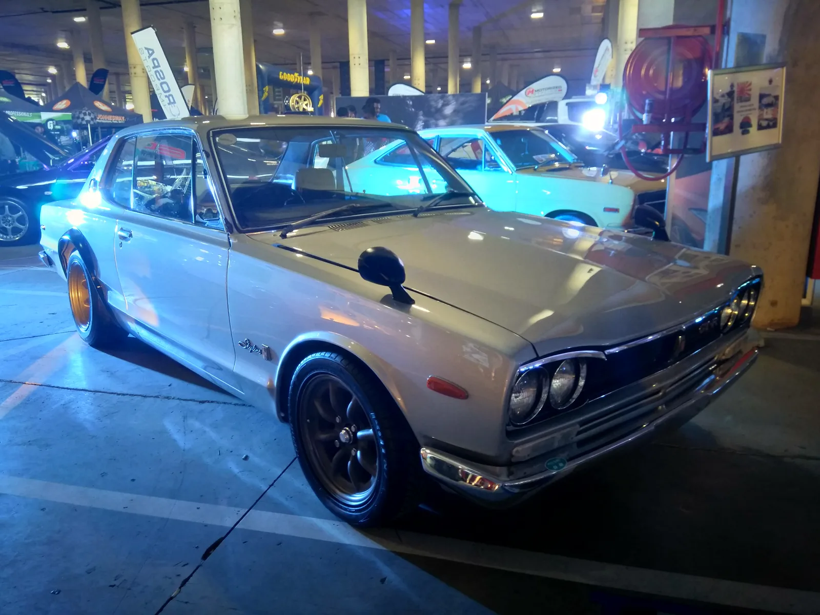 Skyline 2000GT-R สีเงิน ล้อทองแดง หน้าสามส่วน จอดในลานงานรถเก่า