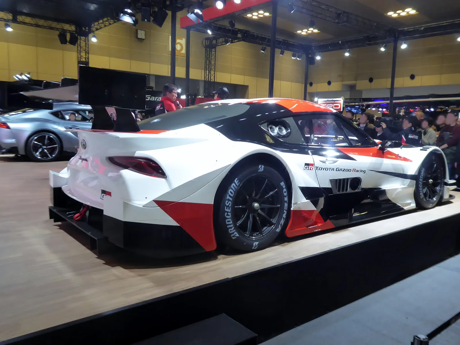 GR Supra รุ่นต้นแบบรถแข่ง SUPER GT สีขาวแดง มุมท้ายสามส่วน เห็นปีกหลังและไฟท้าย