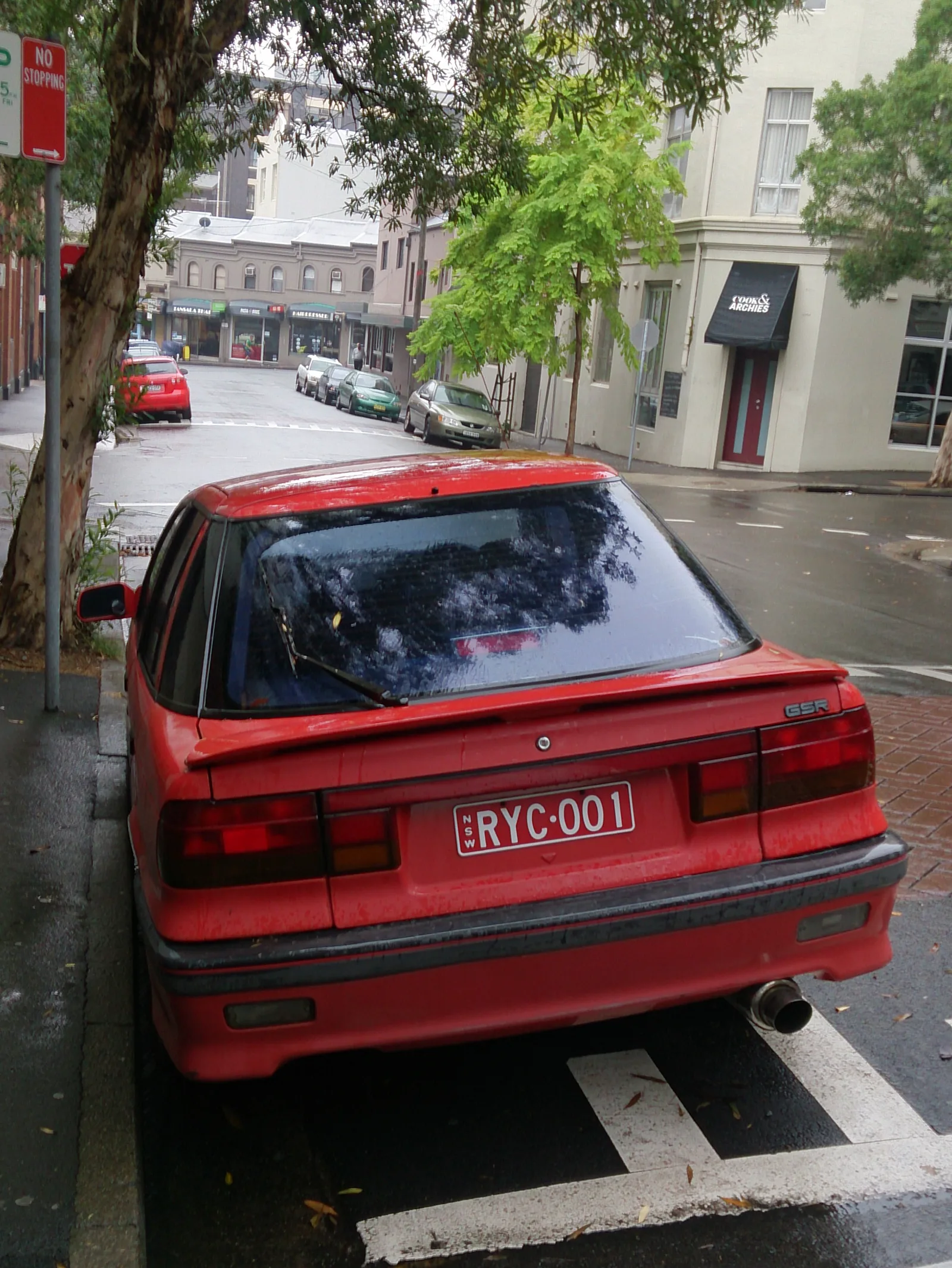 Lancer GSR (CB) สีแดง มุมท้ายสามส่วน ไฟท้ายและสปอยเลอร์ฝาท้ายหลังฝนตก