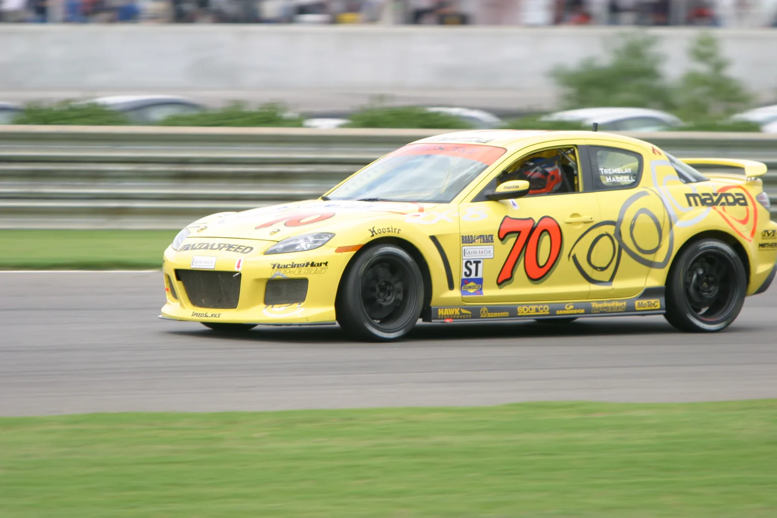 RX-8 รถแข่งสีเหลืองเบอร์ 70 กำลังวิ่งในสนามรายการ Grand-Am Cup
